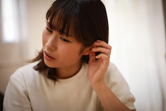 耳を触る女性の画像